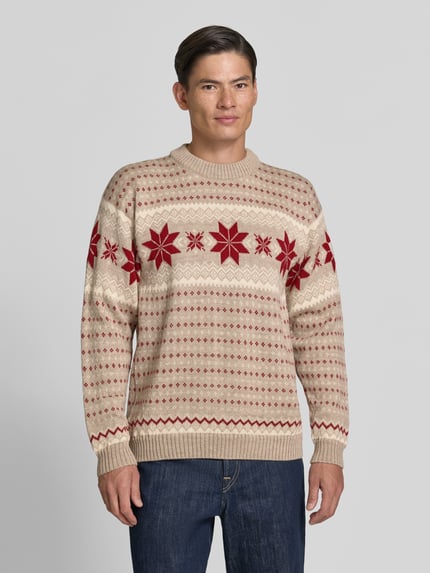 Männermodel trägt Regular Fit Wollpullover in Strick-Optik Modell 'Egersund' von Dale of Norway in Beige und Rot, reine Wolle, Ganzkörperansicht von vorne.