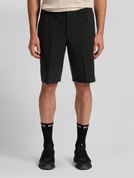 Männermodel trägt Regular Fit Shorts mit elastischem Bund Modell 'S_SPEEDFLEX' von BOSS Green in Schwarz, unifarben, Ganzkörperansicht von vorne.