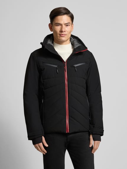 Männermodel trägt Steppjacke mit Kapuze Modell 'KARRAVAARA' von LUHTA in Schwarz mit roten Reißverschlüssen, Regular Fit, Ganzkörperansicht von vorne.
