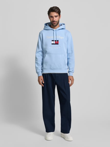 Mannenmodel draagt Weite Fit Hose aus reiner Baumwolle Modell 'MURRAY' van Tommy Hilfiger, effen donkerblauw, met riemlussen, achterzakken en steekzakken, katoenen textuur, wide fit. Volledige lichaamsaanzicht van voren.