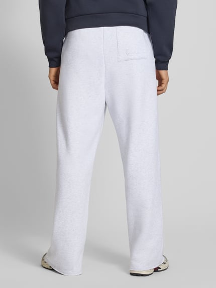 Männermodel trägt Straight Leg Sweatpants mit elastischem Bund van KARL KANI van katoenmix met achterzak, binnenbeenlengte maat M 39 cm. Ganzkörperansicht Rückansicht.