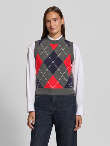 Frauenmodel trägt Pullunder mit Rundhalsausschnitt Modell 'BIMBU' von MANGO, grau mit rot-blauem Rautenmuster, Material-Mix mit Woll-Anteil, gerader Schnitt, Ganzkörperansicht von vorne.