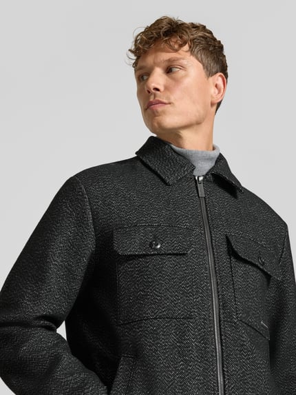 Männermodel trägt Hemdjacke mit Label-Detail van TOM TAILOR, meerkleurig geruit, met borstzakken en ritssluiting, nahaufnahme oberkörper