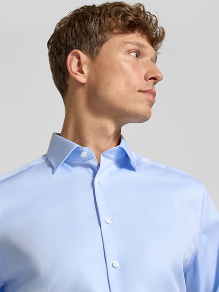 Männermodel trägt Regular Fit Businesshemd aus reiner Baumwolle von OLYMP in Hellblau, Nahaufnahme Oberkörper, Herren Businesshemd von OLYMP.