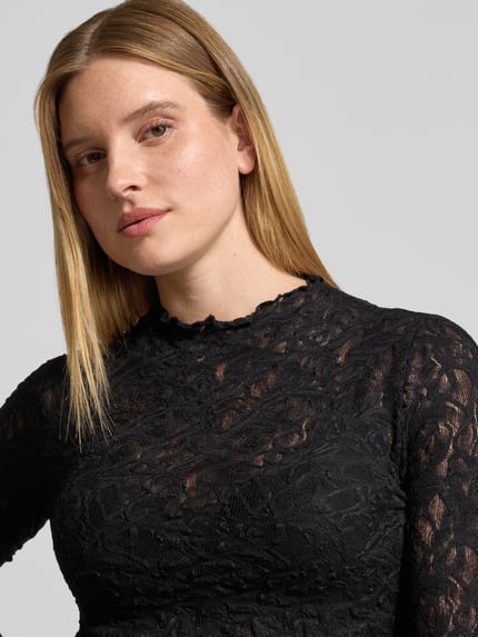 Frauenmodel trägt Langarmshirt mit Ausbrenner-Effekt von s.Oliver BLACK LABEL in Schwarz mit floraler Struktur, Nahaufnahme Oberkörper.