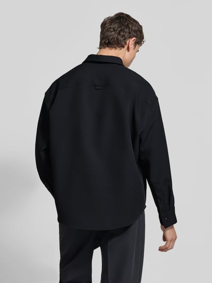 Männermodel trägt Oversized Hemdjacke mit Kentkragen Modell 'STUDIO' von SEIDENSTICKER, schwarz, Regular Fit, Rückansicht, Freizeit-Look.