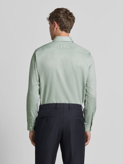 Männermodel trägt Regular Fit Business-Hemd mit Kentkragen von Christian Berg Men in Hellgrün, Reine Baumwolle, Rückenansicht Ganzkörperansicht. Rückenlänge 78 cm, Schulterbreite 45 cm, Ärmellänge 65 cm, Langärmeliges Design, durchgängige Knopfleiste, Größe 39/40.