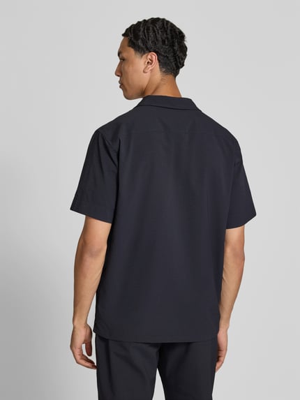 Männermodel trägt Freizeithemd mit Brusttasche von Closed in Dunkelblau, Elastischer-Material-Mix, Regular-Fit, Reverskragen, Rückenansicht, Ganzkörperansicht Rückansicht.