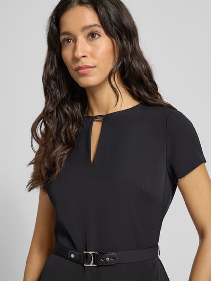 Kobieta modelka nosi Knielanges Kleid mit Taillengürtel od Lauren Ralph Lauren, taliowany krój, długość do kolan, wycięcie w kształcie łezki, pasek w talii, wszyty zamek błyskawiczny, długość tyłu 99 cm, szerokość w biuście 34 cm, długość rękawa 14 cm, kolor czarny, gładka tekstura, prosty krój, detal górnej części, nahaufnahme górnej części ciała.
