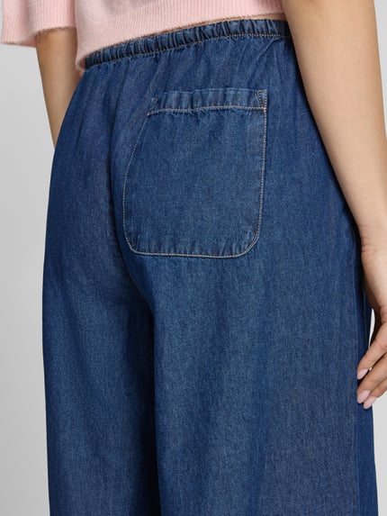 Frauenmodel trägt Pull-on-Jeans mit weitem Bein und Kordelzug von REVIEW aus reiner Baumwolle, blaue Farbe, Gesäßtasche, Detailaufnahme Rückansicht.