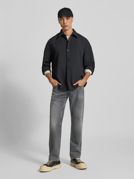 Männermodel trägt Bootcut Fit Jeans aus reiner Baumwolle von Closed im Used-Look, 5-Pocket-Design, Grautöne, Ganzkörperansicht von vorne.