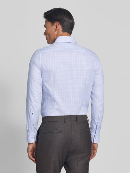 Männermodel trägt Slim Fit Businesshemd aus reiner Baumwolle von Seidensticker, hellblau kariert, glatte Textur, Ganzkörperansicht Rückansicht.