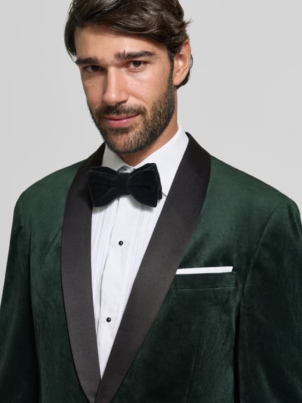 Männermodel trägt Slim Fit Anzug aus Samt von Lindbergh in Dunkelgrün mit Schalkragen, Nahaufnahme Oberkörper.
