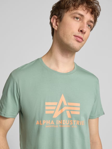Männermodel trägt T-Shirt mit Label-Detail Modell 'BASIC' von Alpha Industries, Reine Baumwolle, Gerader-Schnitt, Rundhalsausschnitt, Nahaufnahme Oberkörper.