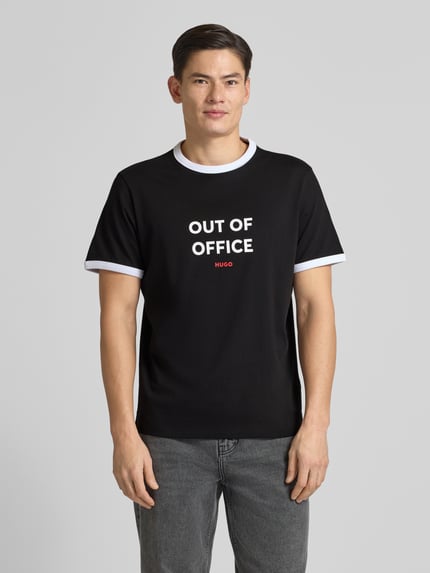 Männermodel trägt Regular Fit T-Shirt aus reiner Baumwolle Modell 'DOFFICE' von HUGO, unifarben, Label-Print, Rundhals, Kurzarm, Ganzkörperansicht von vorne.