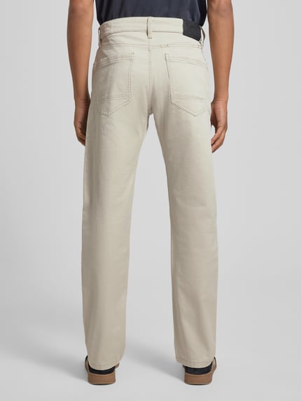 Männermodel trägt Regular Fit Chino aus Baumwoll-Mix van s.Oliver RED LABEL, uniekkleurig, mid waist, label patch, 5-pocket, achteraanzicht, ganzkörperansicht Rückansicht.
