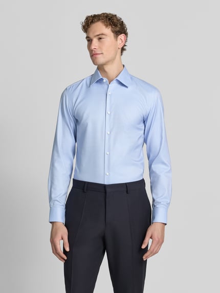 Męski model nosi jasnoniebieską koszulę o kroju slim fit z bawełny, model 'H-HANK-K' od BOSS. Ganzkörperansicht von vorne.