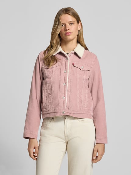 Frauenmodel trägt Regular Fit Jeansjacke aus reiner Baumwolle Modell 'ORIGINAL SHERPA TRUCKER' von Levi's® 300 in Rosa mit heller Textur, Nahaufnahme Oberkörper.