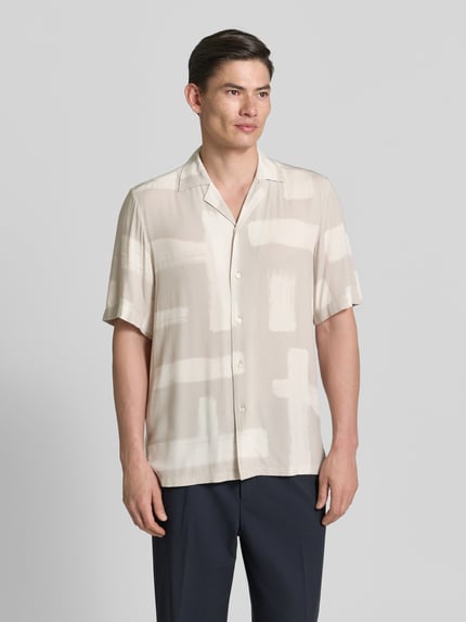 Männermodel trägt Regular Fit Freizeithemd aus Viskose Modell 'RAYER_M' von BOSS Orange, beigefarbenes Allover-Muster, kurzarm, Ganzkörperansicht von vorne
