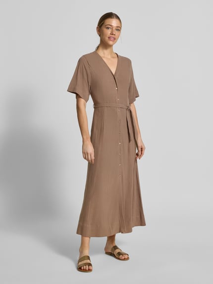Frauenmodel trägt Regular Fit Leinenkleid mit V-Ausschnitt Modell 'VIVA' von Selected Femme, Optik: Unifarben, Maxi-Länge, Bindegürtel, Knopfleiste, Material: Viskose-Leinen-Mix, seitliche Eingrifftaschen, ganzkörperansicht von vorne.