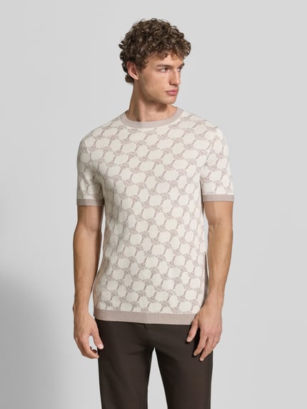 Männermodel trägt T-Shirt mit Viskose-Anteil und Rundhalsausschnitt Modell 'Ravao' von JOOP! Collection, Modern Fit, cremebraunes Muster, Nahaufnahme Oberkörper.