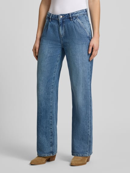 Frauenmodel trägt Wide Leg Jeans im Used-Look von Gina Tricot, blaue Baumwolle, lockerer Schnitt, Eingrifftaschen, Nahaufnahme Oberkörper.