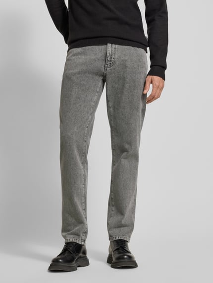 Männermodel trägt Jeans mit 5-Pocket-Design von WOODBIRD in Grau, gerader Schnitt aus Baumwolle, Nahaufnahme Oberkörper bis Fuß.
