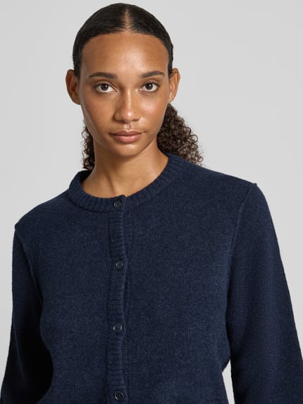 Frauenmodel trägt Strickjacke mit Rundhalsausschnitt und Knopfleiste von Oui, dunkelblau, Material-Mix mit Woll-Anteil, Nahaufnahme Oberkörper.
