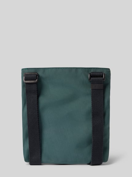 Produktfoto, grüne Crossbody Bag mit Label-Stitching von CK Calvin Klein, schwarzer verstellbarer Schulterriemen, matte Textur, Hauptfach mit Reißverschluss, Maße 21x21x3 cm