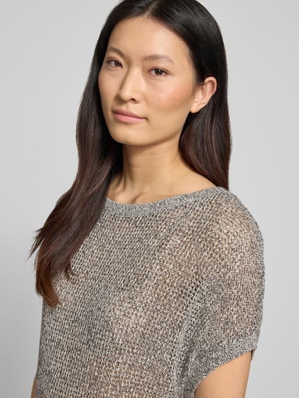 Frauenmodel trägt Relaxed Fit T-Shirt in Strick-Optik von Comma aus reiner Baumwolle, semitransparent, kurzärmelig, Nahaufnahme Oberkörper.