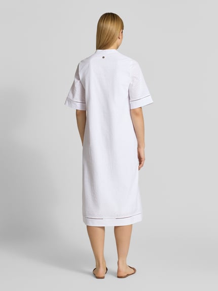 Frauenmodel trägt Tunikakleid mit V-Ausschnitt Modell 'Debra' von JOOP!, reine Baumwolle, weiße Farbe, A-Linie, Midikleid, Ganzkörperansicht Rückansicht.