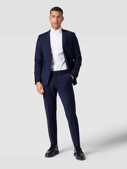 Männermodel trägt Regular Fit Sakko mit woll-anteil model 'Irving' van Drykorn in donkerblauw, elastische materiaalmix, reverskraag, 2-knoopsluiting, paspelzakken, borstzak, regular fit, geheel lichaamsaanzicht van voren.