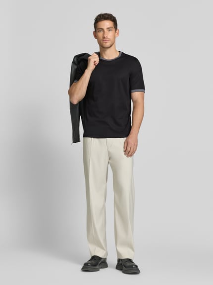 Männermodel trägt T-Shirt mit Rundhalsausschnitt von bugatti, schwarz, Baumwoll-Mix, Regular Fit, Label-Detail, Ganzkörperansicht von vorne.