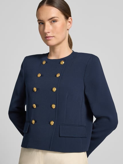 Modelka nosi Regular Fit Kurzblazer mit Zierknöpfen von Lauren Ralph Lauren w kolorze granatowym z ozdobnymi guzikami, teksturowana tkanina, zbliżenie na górną część ciała z przodu.