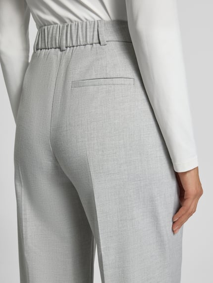 Vrouwenmodel draagt stoffen broek met bandplooien Model 'Catsby' van Someday, materiaalmix met viscose, achterzak, los model, detailopname rug.