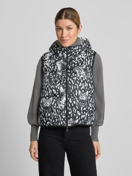Frauenmodel trägt Regular Fit Weste mit Wendefunktion von Marc Cain in Schwarz-Weiß mit animalischem Muster, Ganzkörperansicht von vorne, Damen Weste von Marc Cain.