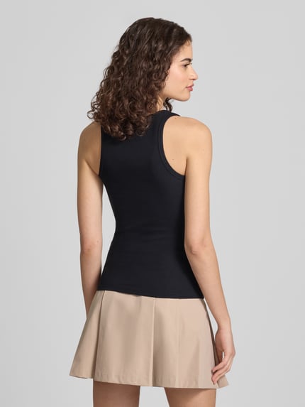Frauenmodel trägt Tanktop mit Rundhalsausschnitt von Review aus Baumwoll-Mix mit Stretch-Anteil, Feinripp, Körpernaher-Schnitt, Ganzkörperansicht Rückansicht.