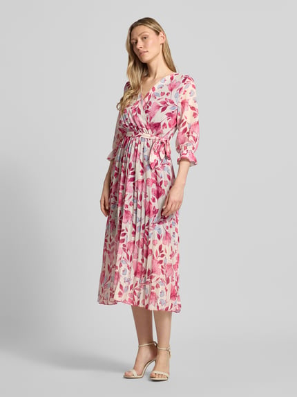 Frauenmodel trägt Midikleid mit Bindegürtel Modell 'Momoo' von ZABAIONE mit Wickel-Optik, V-Ausschnitt, 3/4-Arm, florales Muster, Taillierte Passform, Rückenlänge 118 cm, Brustweite 43 cm, Ärmellänge 44 cm, Ganzkörperansicht von vorne.