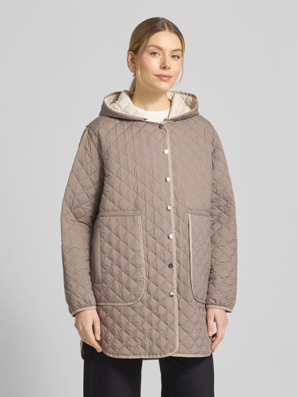 Frauenmodel trägt Steppmantel mit Druckknopfleiste von WHITE LABEL in Taupe mit Kapuze und aufgesetzten Eingrifftaschen, lockere Passform, Rückenlänge bei Größe 36: 74 cm, Schulterbreite: 46 cm, Brustweite: 55 cm, Ärmellänge: 61 cm, Ganzkörperansicht von vorne.