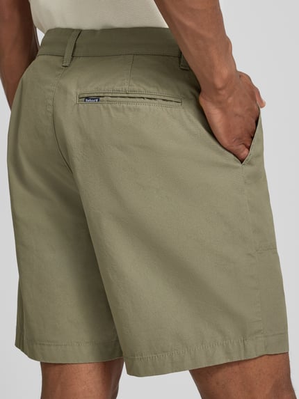 Männermodel trägt Regular Fit Chinoshorts aus reiner Baumwolle Modell 'SHERBURN' von Barbour in Olivgrün, Herren, Ganzkörperansicht Rückansicht.
