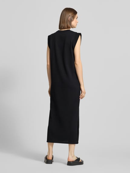 Frauenmodel trägt Regular Fit Sweatkleid aus Baumwoll-Mix Modell 'CHILLI SUMMER' von Pieces, Optik: Unifarben, Maxi-Länge, Rundhals-Ausschnitt, Ärmelform: Ohne, Saum: Seitenschlitze, Materialverarbeitung: Sweat, Farbe einfarbig, glatte Textur, Ganzkörperansicht Rückansicht.