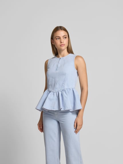 Vrouwenmodel draagt Slim Fit Top in Denim-Optiek van BAUM & PFERDGARTEN, lichtblauw katoenmix met ruffles, ritssluiting, frontale lichaamsopname.