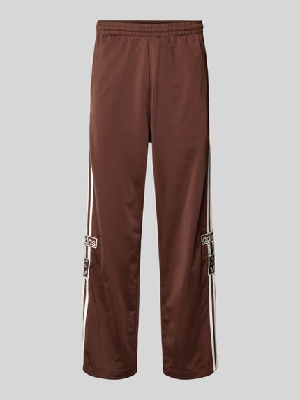 Produktfoto, Wide fit heren joggingbroek met logostitching model 'Adibreak' van adidas Originals, elastische band, knoopsluiting, logopatch, binnenbeenlengte maat M 76 cm, bruin met witte details, gladde stof.