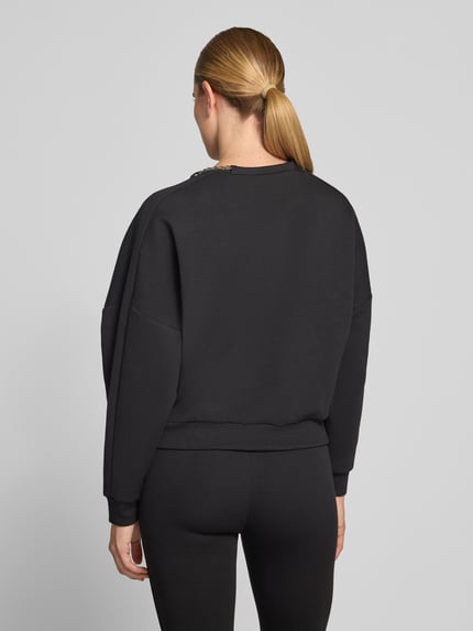 Vrouwenmodel draagt boxy fit sweatshirt uit katoenmix model 'Denrietta' van HUGO, Dames sweatshirt, zwart, gladde textuur, volledige lichaamsweergave achteraan.