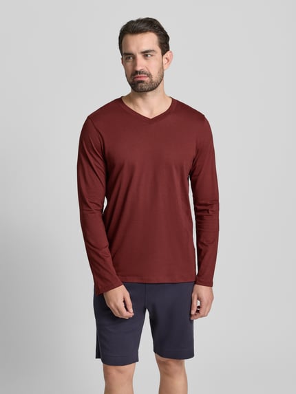 Männermodel trägt Longsleeve mit geripptem V-Ausschnitt von Schiesser in Dunkelrot, reine Baumwolle, Regular Fit, Ganzkörperansicht von vorne.