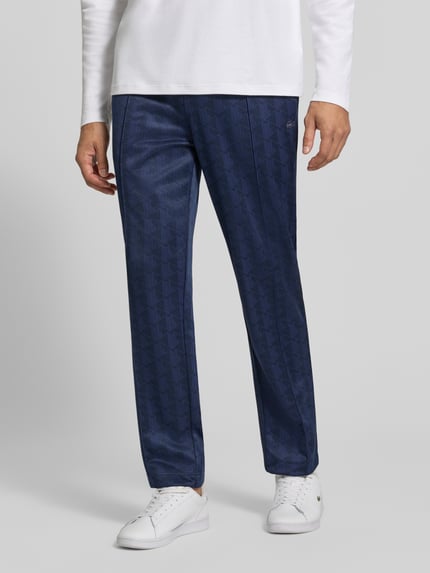 Männermodel trägt eine dunkelblaue Regular Fit Sweathose aus mit Logo-Print von Lacoste, feine Struktur, Herren Sweathose, Ganzkörperansicht von vorne.