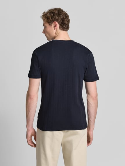 Männermodel trägt T-Shirt in Jaquard-Strick mit Rundhalsausschnitt von Lindbergh in Dunkelblau, strukturierte Baumwolle, Ganzkörperansicht Rückansicht.