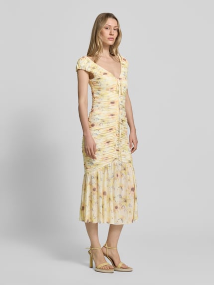 Vrouwenmodel draagt Midikleid met Drapierungen und V-Ausschnitt van Little Mistress, materiaalmix met stretch, nauw aansluitend model, ruglengte maat 36 is 120 cm, pastelgeel met bloemenprint, zachte textuur, Ganzkörperansicht van voren.