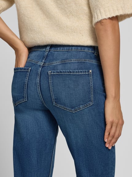 Frauenmodel trägt Bootcut Jeans mit 5-Pocket-Design von Christian Berg Woman, Baumwoll-Viskose-Mix mit Stretch-Anteil, Nahaufnahme Rückansicht.