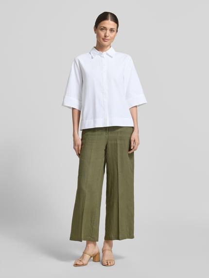 Frauenmodel trägt Regular Fit Hemdbluse im Halbarm-Design Modell 'Netti' von Soyaconcept, weiß, Material-Mix mit Baumwoll-Anteil, Hemdblusenkragen, Ganzkörperansicht von vorne. Rückenlänge bei Größe S: 58 cm, Ärmellänge bei Größe S: 37 cm.